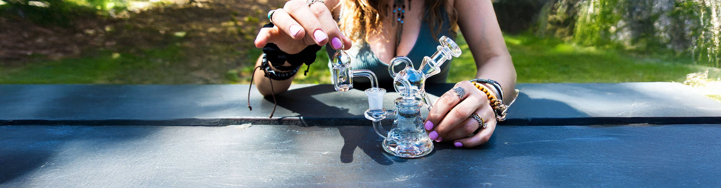 woman sitting at park bench using the Wulf Revo Dab Rig