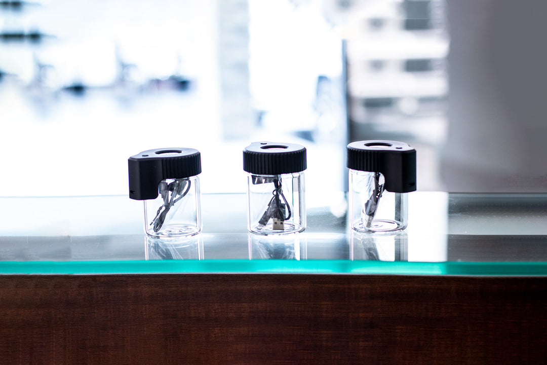 Wholesale Stash Box standing on a glass and wood table facing office front entrance